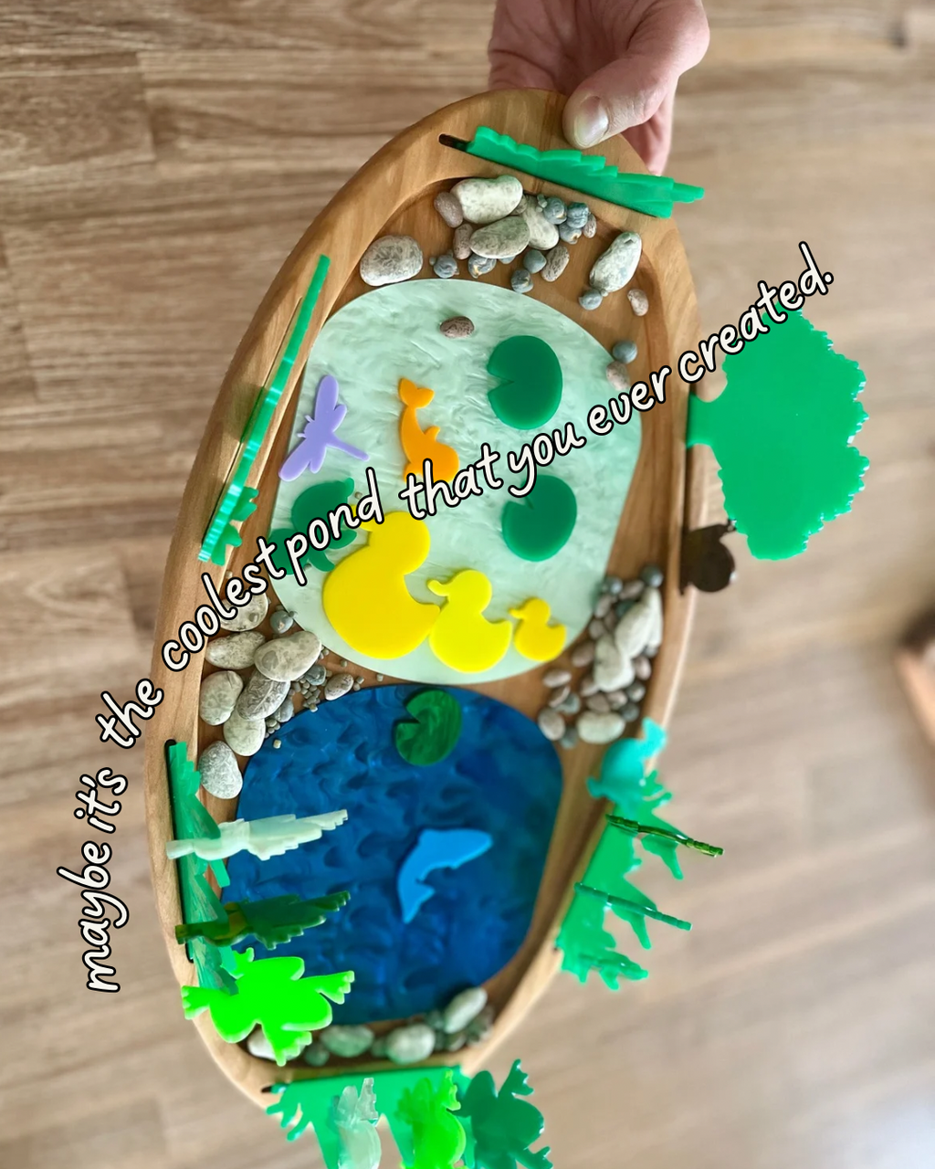 Multipurpose Oval Sensory Tray featuring a wooden tray with textured blue and green sensory fillers, colorful animal and plant shapes, smooth stones, handcrafted, homeschool, education resources.