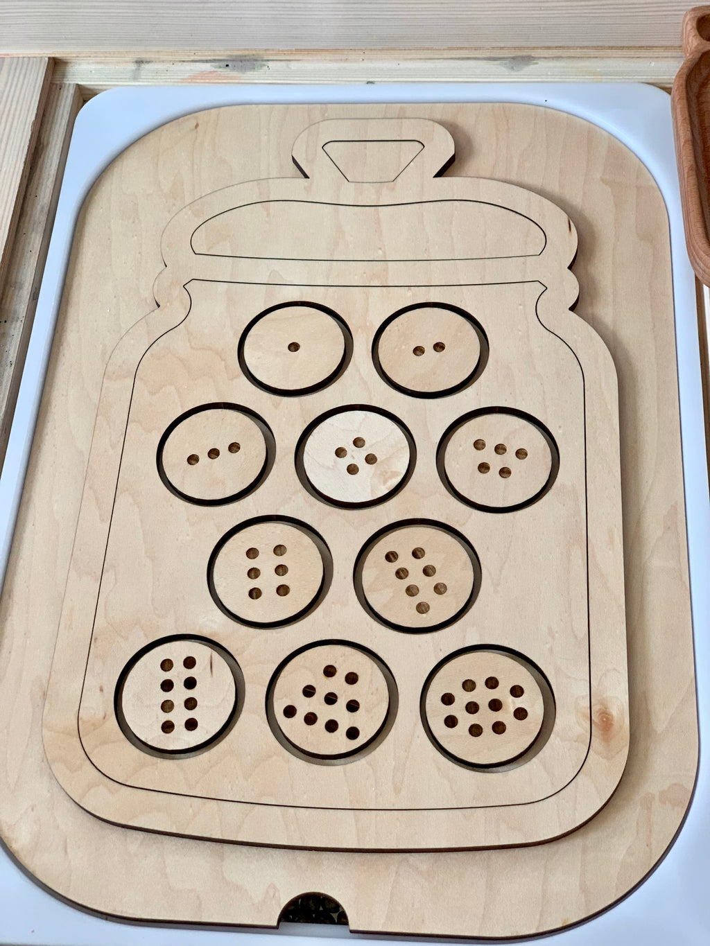 Wooden cookie jar-shaped Flisat insert with ten numbered cookie slots featuring 1-10 chocolate chip holes on light wood background