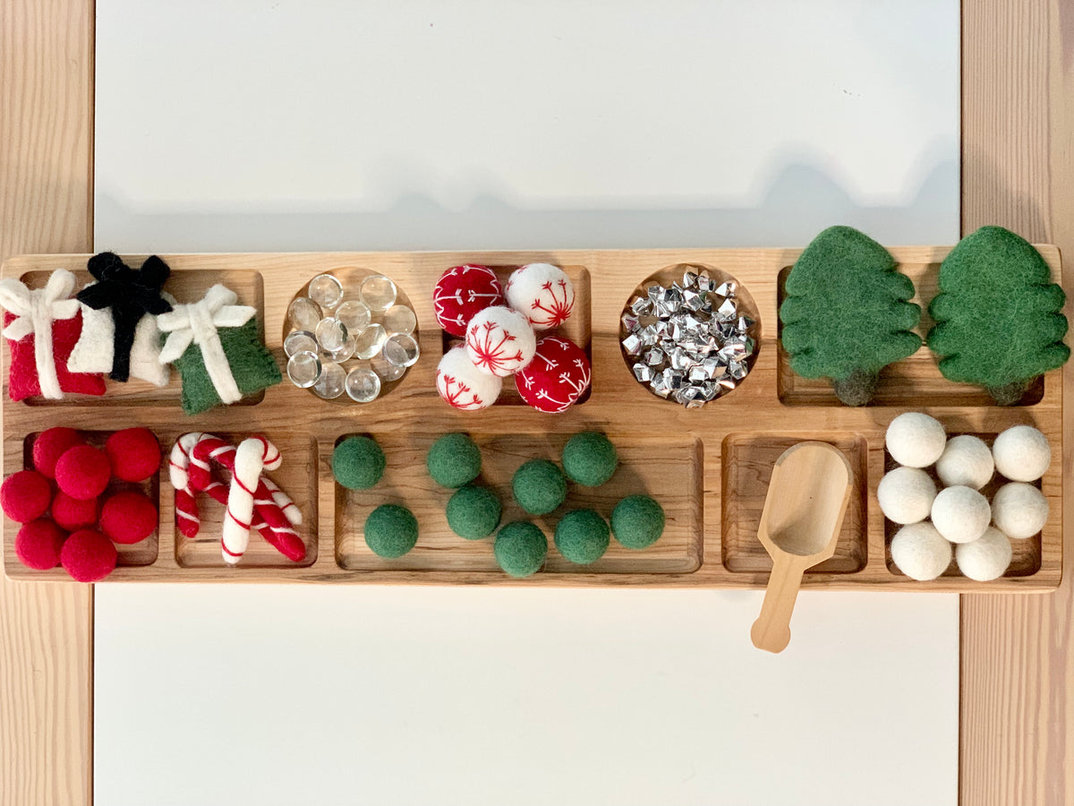Extra large wooden tinker tray plate with compartments holding festive felt balls, candy canes, green trees, and a wooden scoop