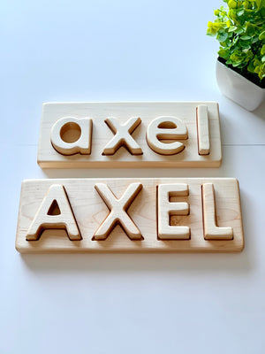 Personalized hardwood name puzzles with uppercase and lowercase engraved letters spelling AXEL on light wood boards