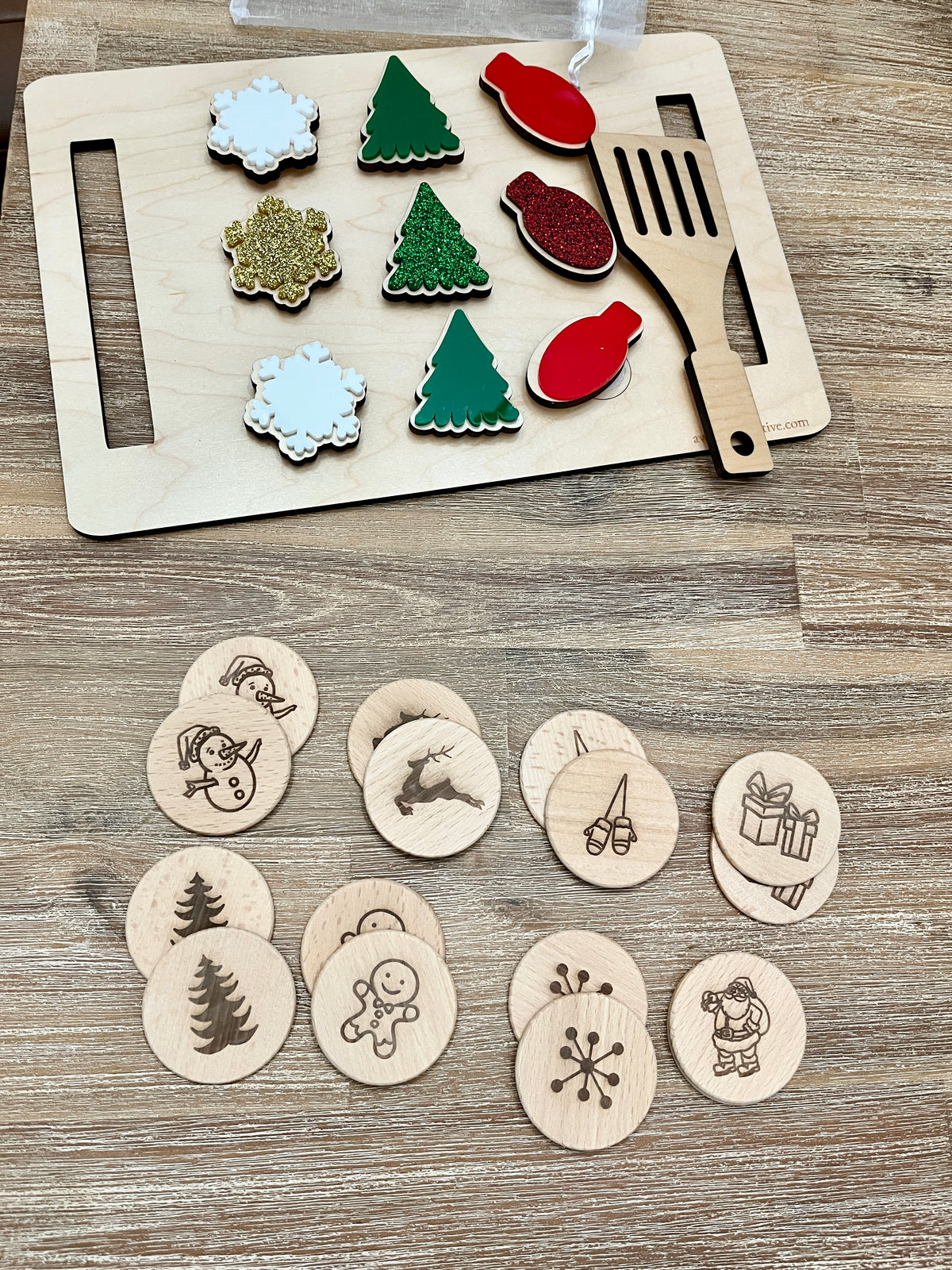 Wooden Christmas memory game pieces including painted snowflakes, trees, ornaments, and engraved holiday icons on wood background