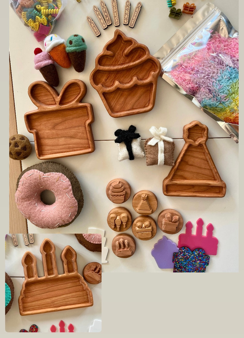 Wooden trays shaped like cupcake, gift box, party hat, felt donuts and ice cream, colorful sprinkles, and small wooden stamps on white surface
