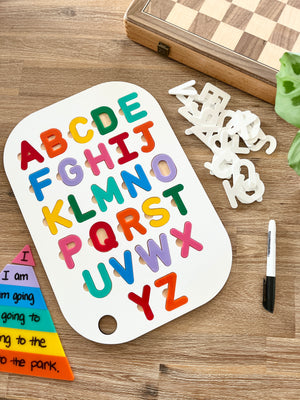 Acrylic Dry Erase Uppercase Alphabet Puzzle Flisat Table Top Insert with Both Rainbow and White Letters showing colorful uppercase letters on white insert, black marker, wood grain surface, handcrafted homeschool education resources.