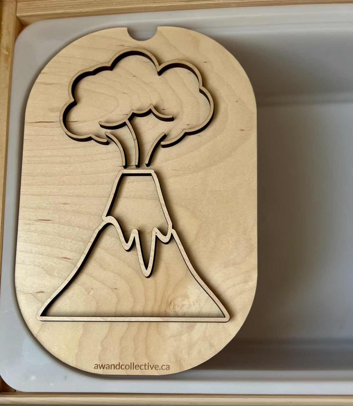 Light wood puzzle board featuring an erupting volcano shape with smoke and lava cutouts