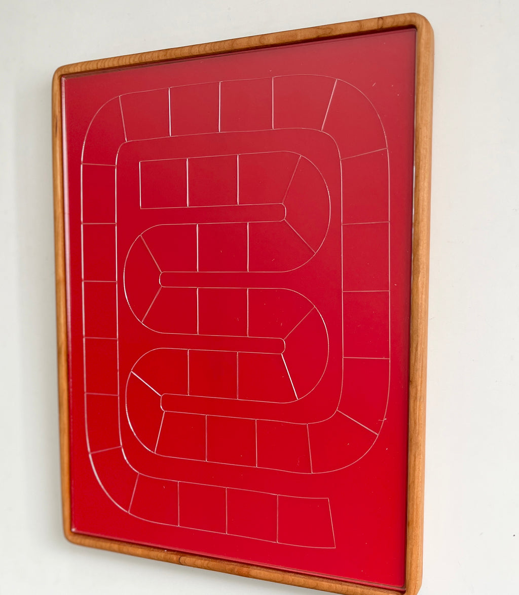 Red rectangular game board with white outlined winding path and wooden frame on white background