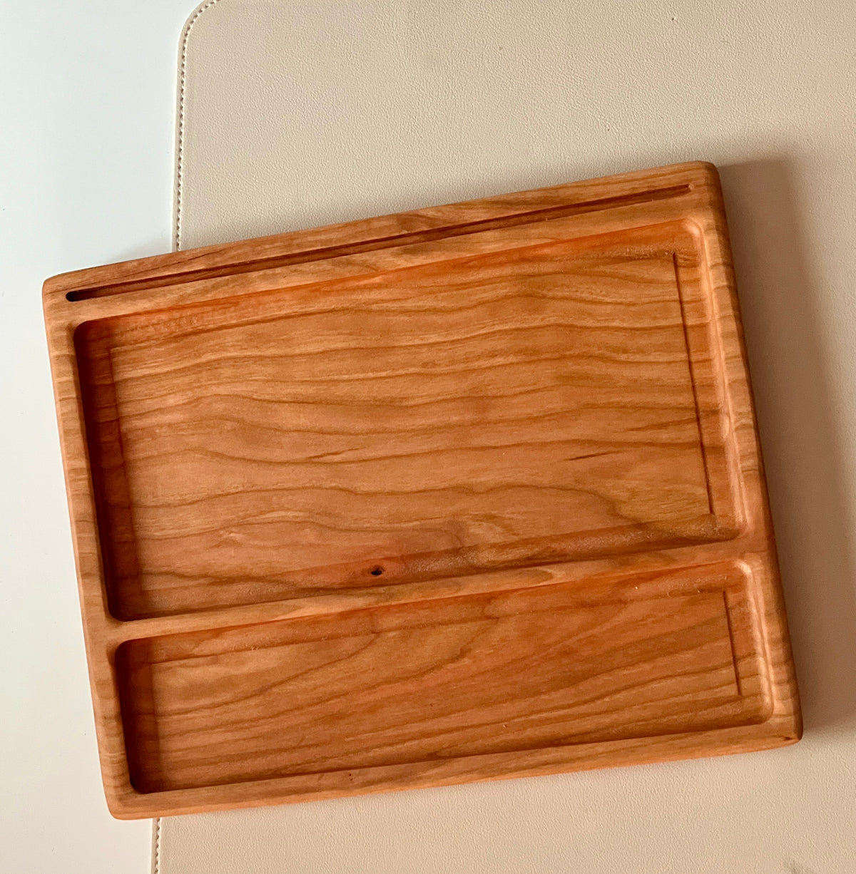 Smaller wooden multipurpose sensory tray with two rectangular carved sections and rounded edges on beige surface