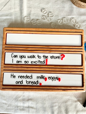 Little Dry Erasables - Mini Punctuation and Loose Parts 26 Pieces showing handcrafted wooden trays with writable white panels featuring handwritten sentences and colorful punctuation marks, handcrafted homeschool educational resources.