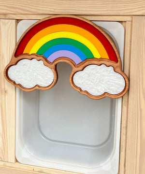 Wooden rainbow puzzle with red, orange, yellow, green, blue, purple arches and two textured white cloud pieces on wood frame