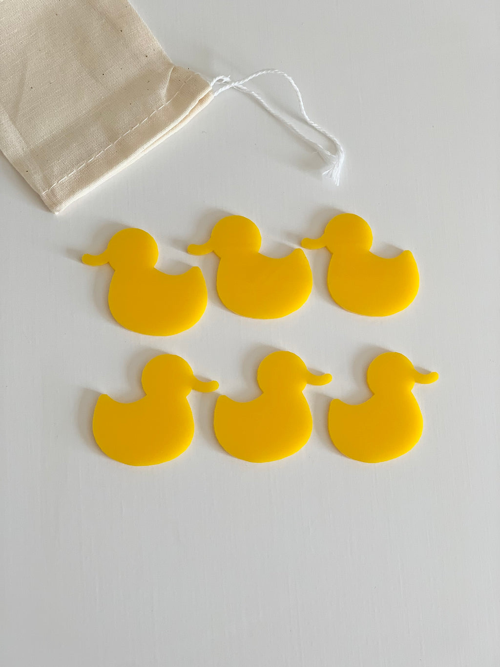 Set of six yellow duck-shaped dry erase boards with natural drawstring storage pouch on white surface