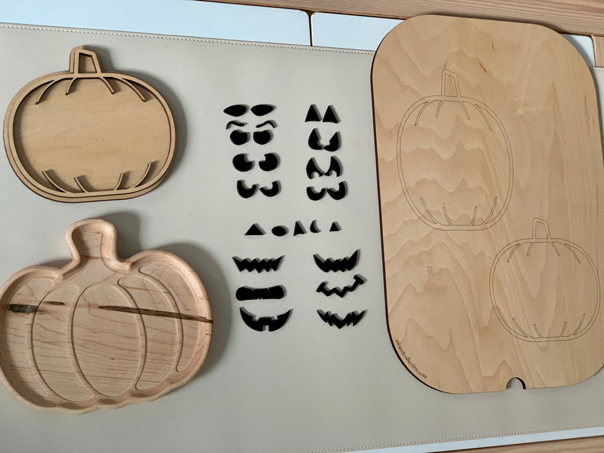 Laser cut wooden pumpkin plate and tray with various interchangeable jack-o-lantern face pieces on light surface