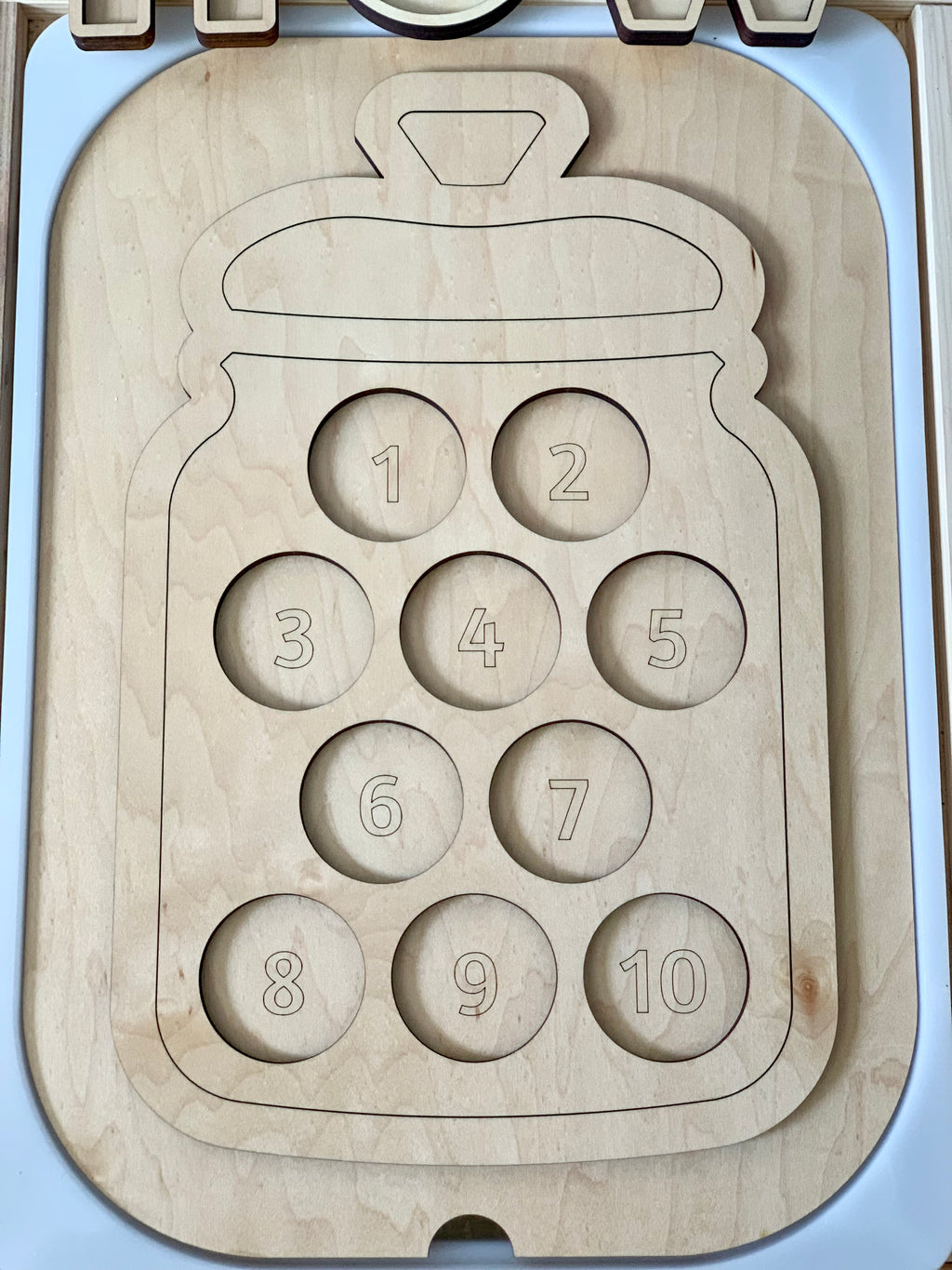Wooden cookie jar-shaped Flisat insert with numbered 1 to 10 circular slots for counting cookies on light wood surface