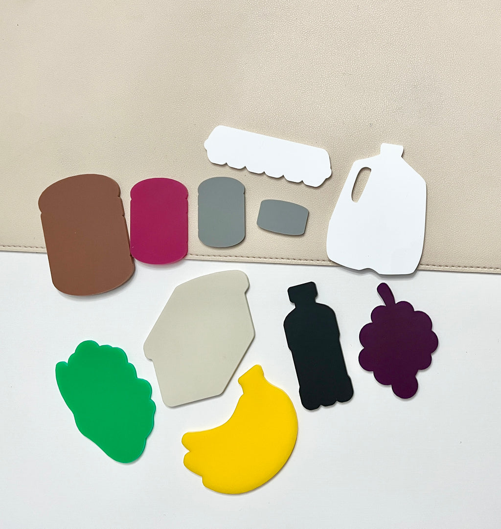 Various colorful flat shapes resembling food items and containers on a white and beige surface