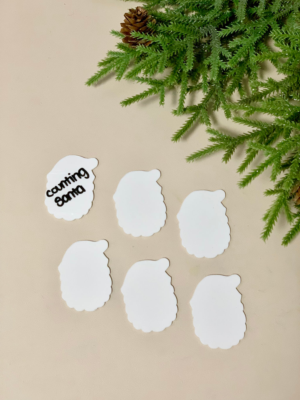 Set of six Santa head-shaped dry erasable whiteboards with one board showing "counting santa" text on beige background with greenery