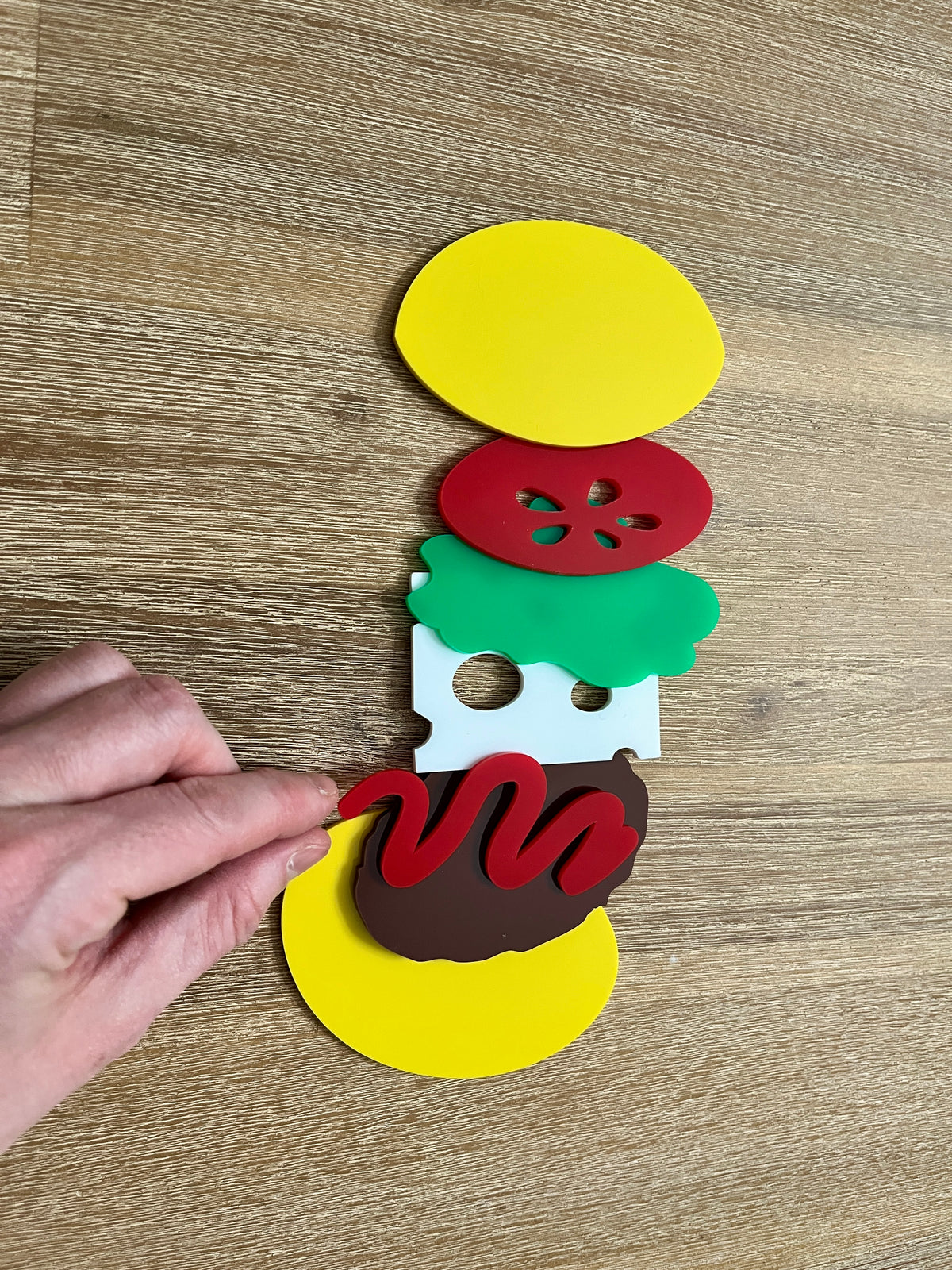 Little Dry Erasables - Burger 7 Piece Set showing handcrafted wooden play pieces including bun halves, tomato slice, lettuce, cheese slice, burger patty, and ketchup, homeschool education resources.