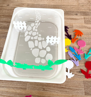 White tray with a stone path and fence design holding colorful acrylic flower-shaped pegs beside it, showcasing STEM Insert – Acrylic Insert with Different Peg Options - Neighborhood, Veggie Garden, Flower Garden, Under the Sea + More, handcrafted, homeschool, education resources.