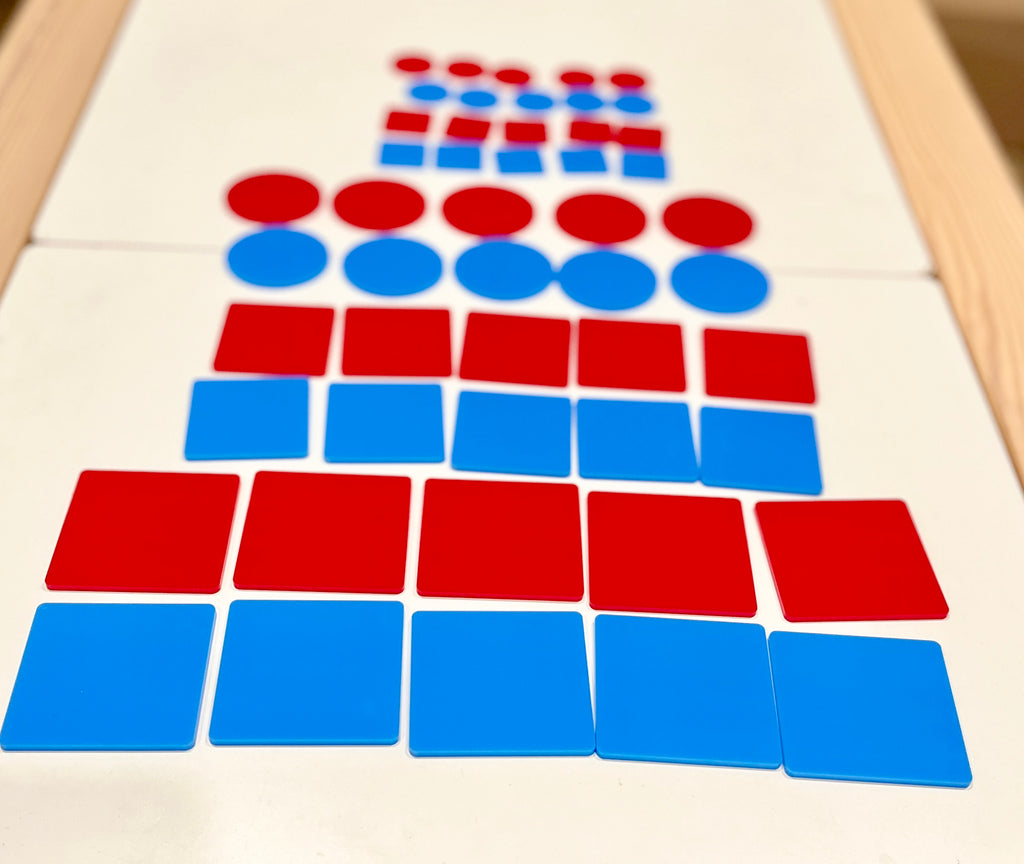 Red and blue flat circular and square plastic tiles stacked in alternating rows on a white surface with a wooden frame