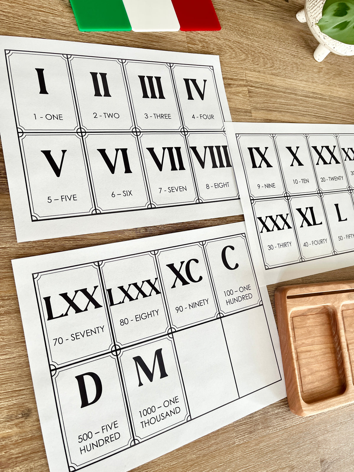 Digital Download | Roman Numeral Flash Cards displaying printable cards with Roman numerals and corresponding numbers in a classic style on a wooden surface, handcrafted homeschool education resources.