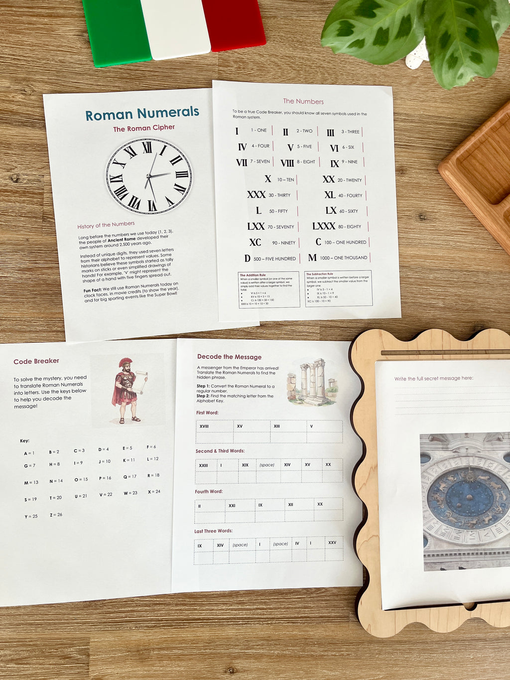 Digital Download | Roman Numerals, Their History & DeCoding Activity featuring printed educational pages with Roman numeral charts, decoding exercises, and a wooden tray on a natural wood surface, handcrafted, homeschool, education resources.