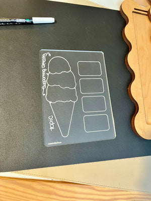 Clear acrylic ice cream cone diagram board with labeled topic and supporting details sections on black surface next to wooden item
