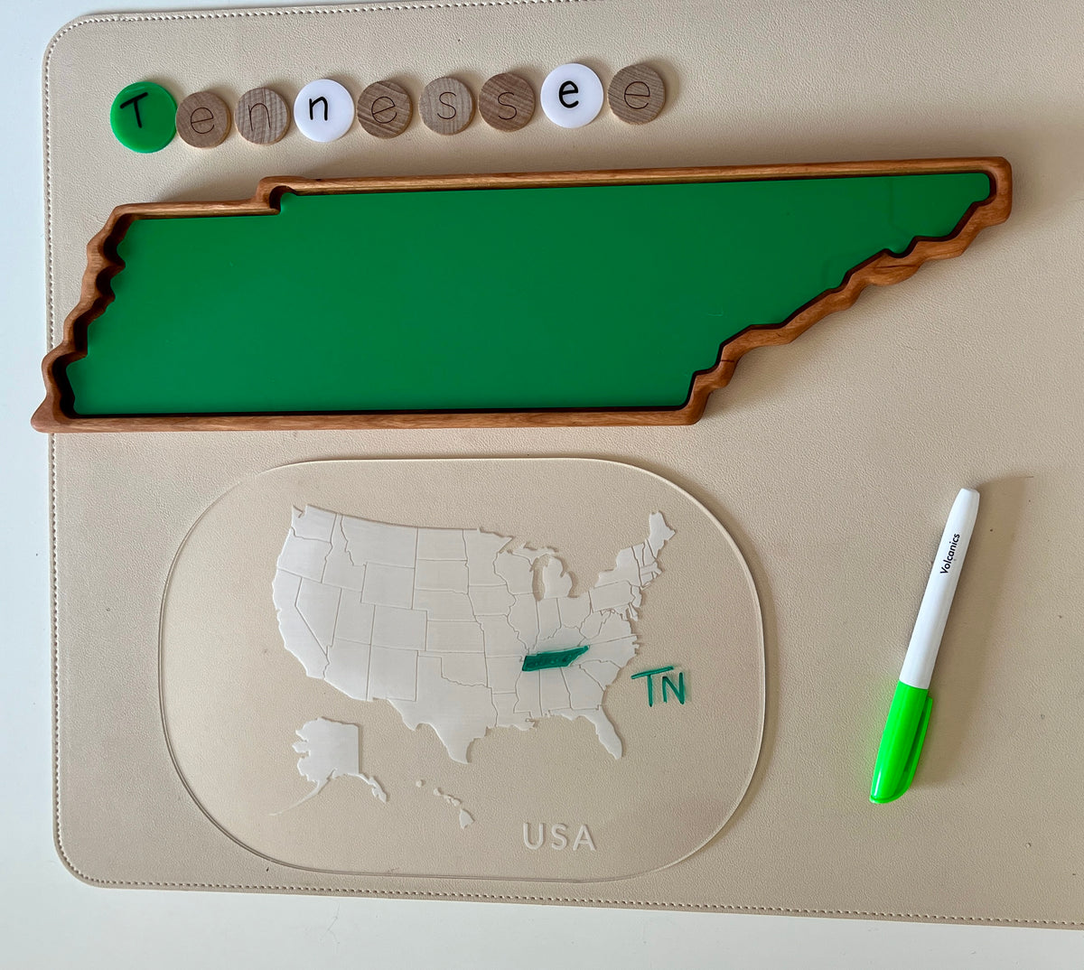 Wooden tray shaped like Tennessee with green insert, USA map puzzle highlighting Tennessee, letter tokens spelling Tennessee, and green marker.