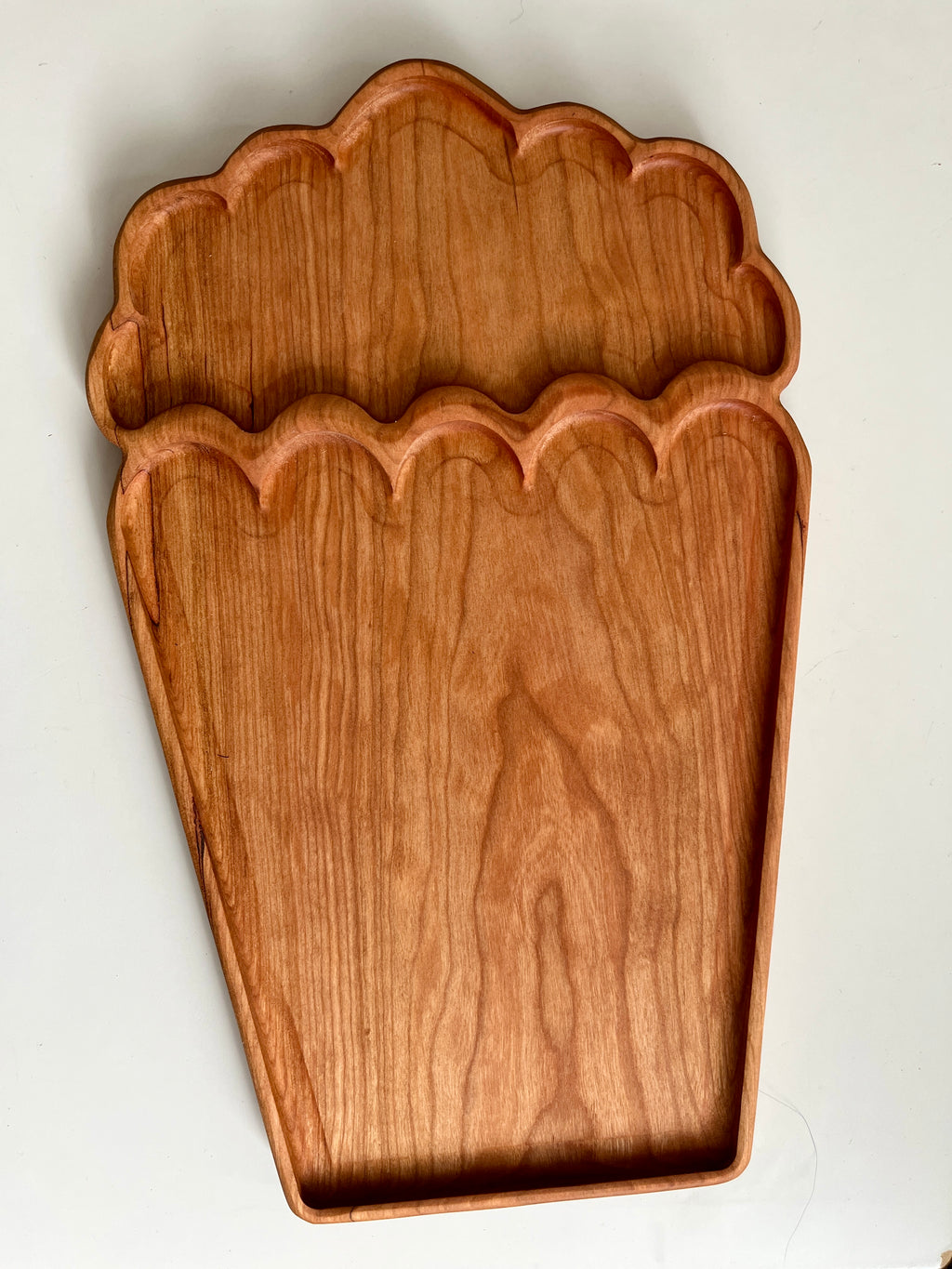 Wooden serving tray shaped like a popcorn container with a natural wood grain finish on white background