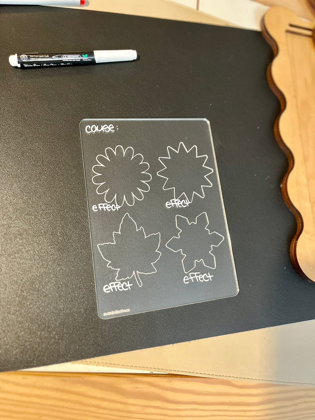 Transparent learning board with flower and leaf outlines labeled cause and effect on a dark desk surface