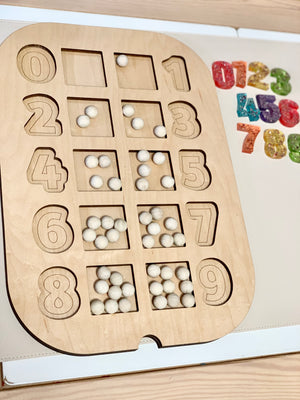 Wooden Flisat number puzzle insert with white beads counting 0 to 9 on light wood table with rainbow resin numbers nearby