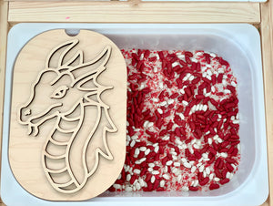 Plastic tub filled with red and white rice with a wooden dragon stencil resting on the edge of the container