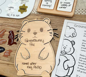 Laser Cut Groundhog Tray with Dry Erase Insert shaped like a groundhog with handwritten educational notes, accompanied by wooden groundhog pieces and seasonal learning materials, handcrafted homeschool education resources.