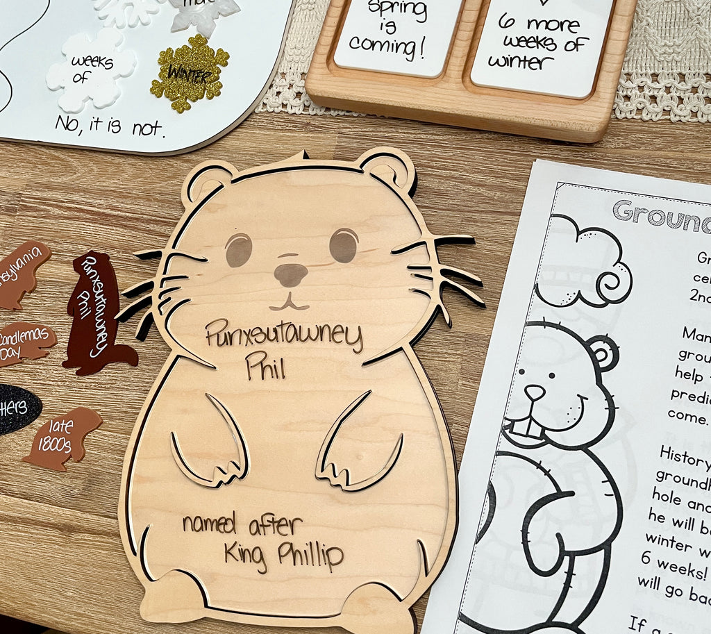 Laser Cut Groundhog Tray with Dry Erase Insert shaped like a groundhog with handwritten educational notes, accompanied by wooden groundhog pieces and seasonal learning materials, handcrafted homeschool education resources.