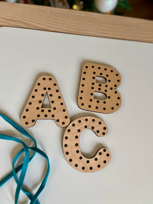 Three wooden letters A, B, and C with holes for threading, accompanied by a blue lace, handcrafted homeschool Alphabet Lacing Letters (A, B, C shown — full alphabet optional) educational resources.
