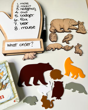 The Mitten Wooden Animals and/or Little Dry Erasables with Mitten Interactive Learning Set showcasing handcrafted wooden animal pieces, colorful silhouettes, a mitten-shaped dry-erase board with handwritten animal names, and a dry-erase marker, unique homeschool education resources.