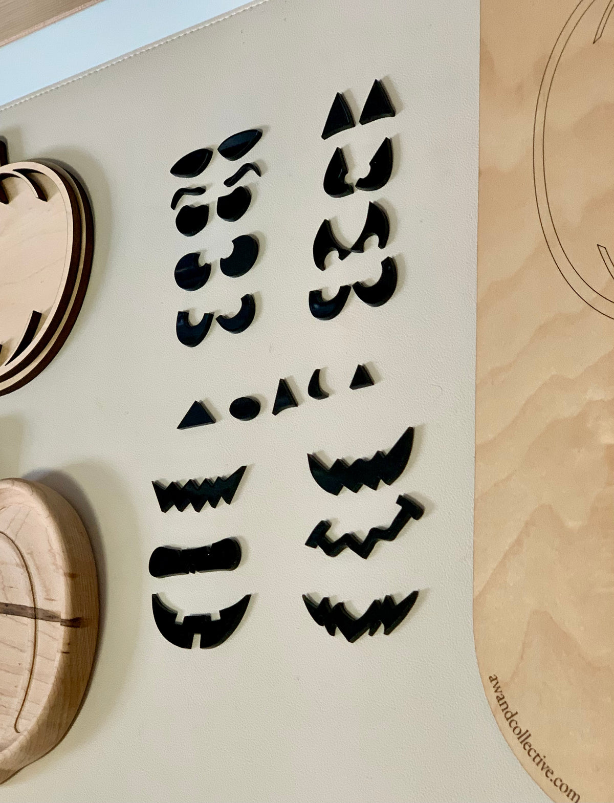 Laser cut jack o lantern facial features including eyes, noses, and mouth shapes for pumpkin sensory play tray