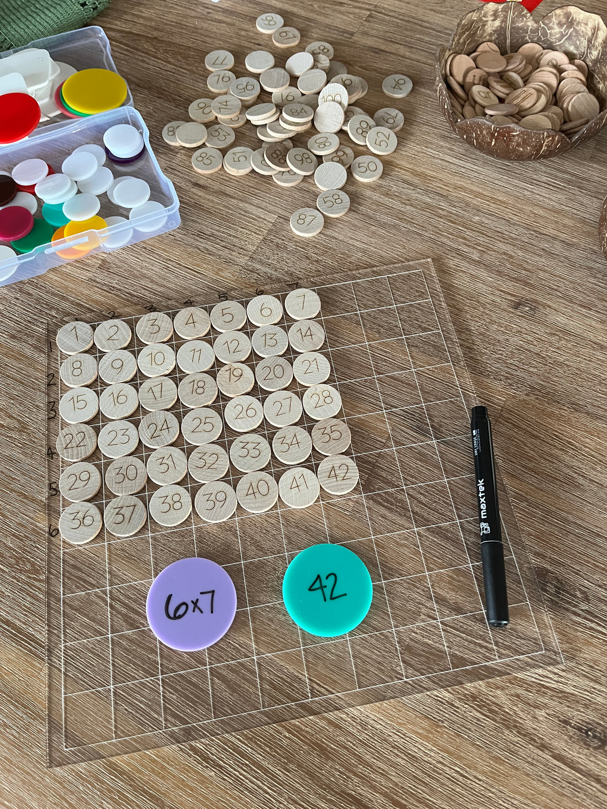 Dry Erasable Blank Open Ended 100 Frame Hundred Board showing translucent grid board with wooden number discs arranged in numerical order, colorful counters, black dry erase marker, handcrafted homeschool education resources.