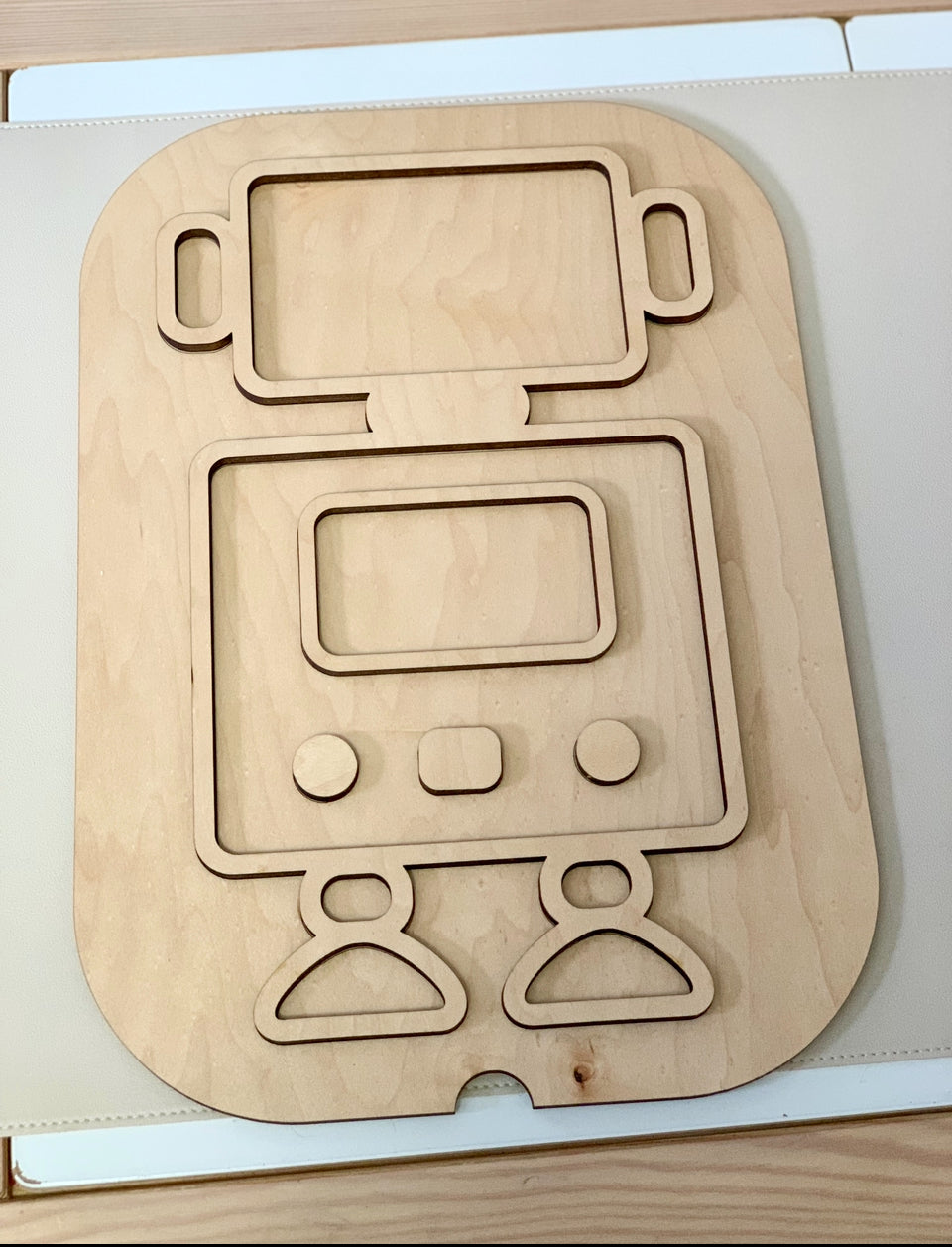 Maple plywood robot-shaped Flisat table top insert with cutouts for head, body, arms, and legs on light surface
