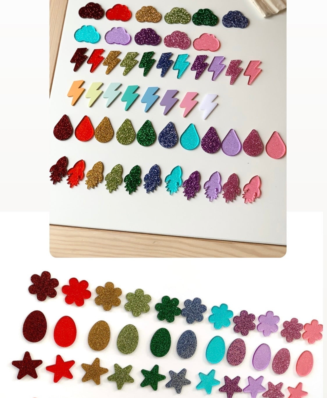 Rows of colorful glittery plastic shapes including clouds, lightning bolts, water drops, and rockets arranged on a white surface