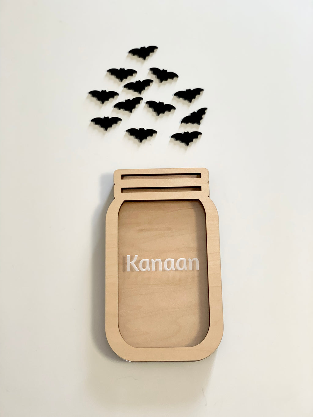 Personalized wooden jar shaped reward container with name and small black bat cutouts on white background