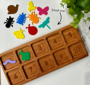 Wooden number board with engraved digits 1 to 10 and colorful small insect and bug-shaped puzzle pieces nearby