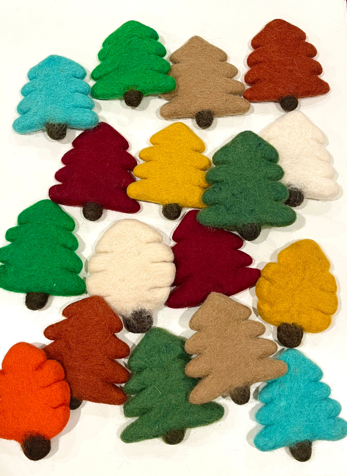 Assorted felt tree shapes in various colors including teal, green, brown, red, yellow, white, and orange on a white background