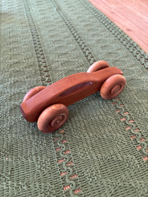 Ready to Ship, Push Cars, 10 Colours / Styles showing a smoothly carved wooden toy car with rounded wheels made from rich wood tones, handcrafted homeschool educational resource.