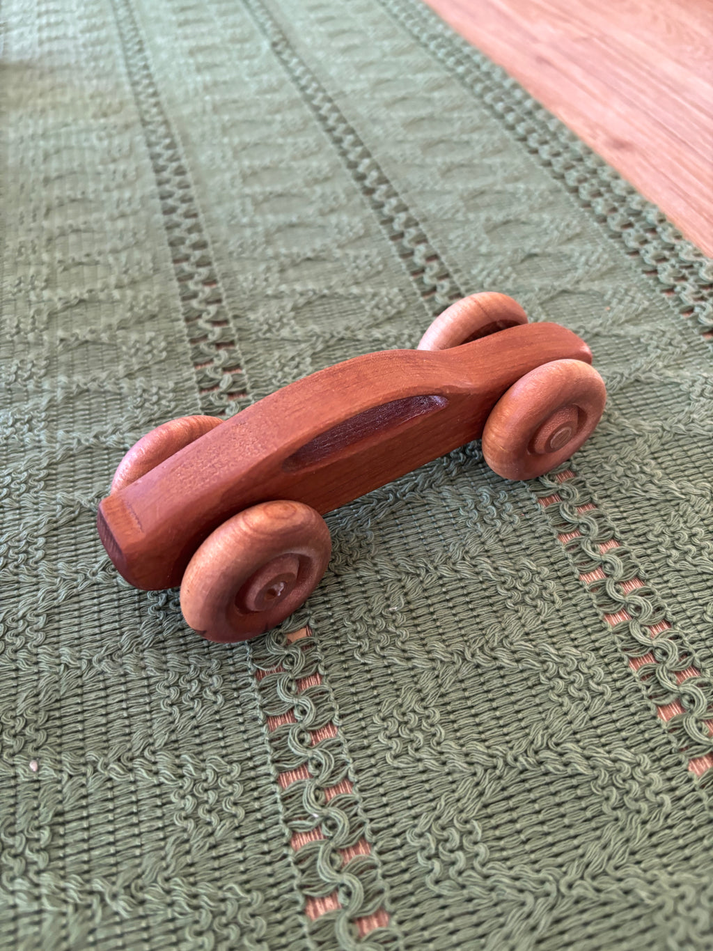 Ready to Ship, Push Cars, 10 Colours / Styles showing a smoothly carved wooden toy car with rounded wheels made from rich wood tones, handcrafted homeschool educational resource.