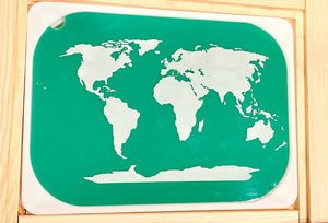 White world map silhouette on a green rectangular board with rounded corners inside a wooden frame