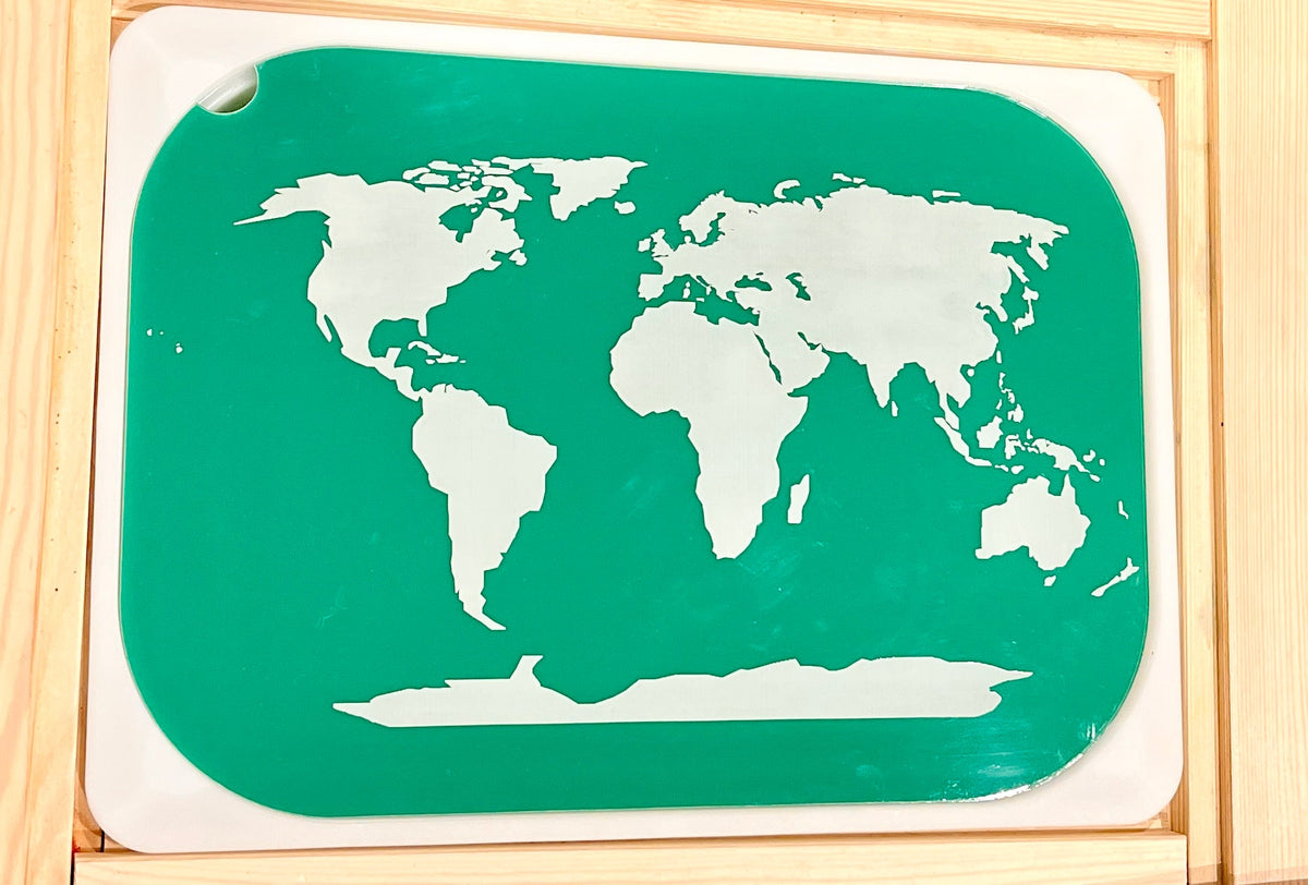 White world map silhouette on a green rectangular board with rounded corners inside a wooden frame