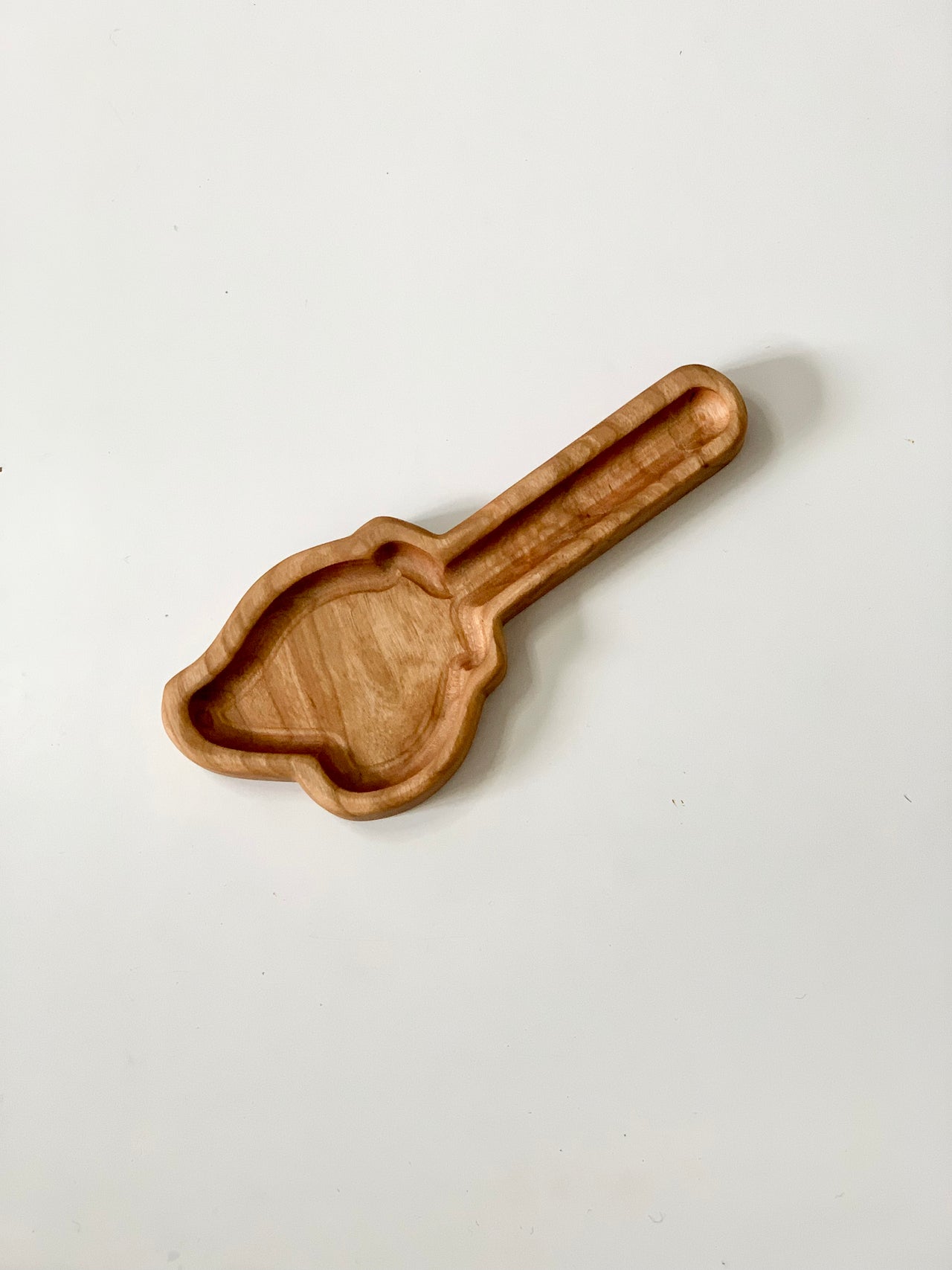 Wooden sensory tray shaped like a witch's broom with a smooth finish on white background