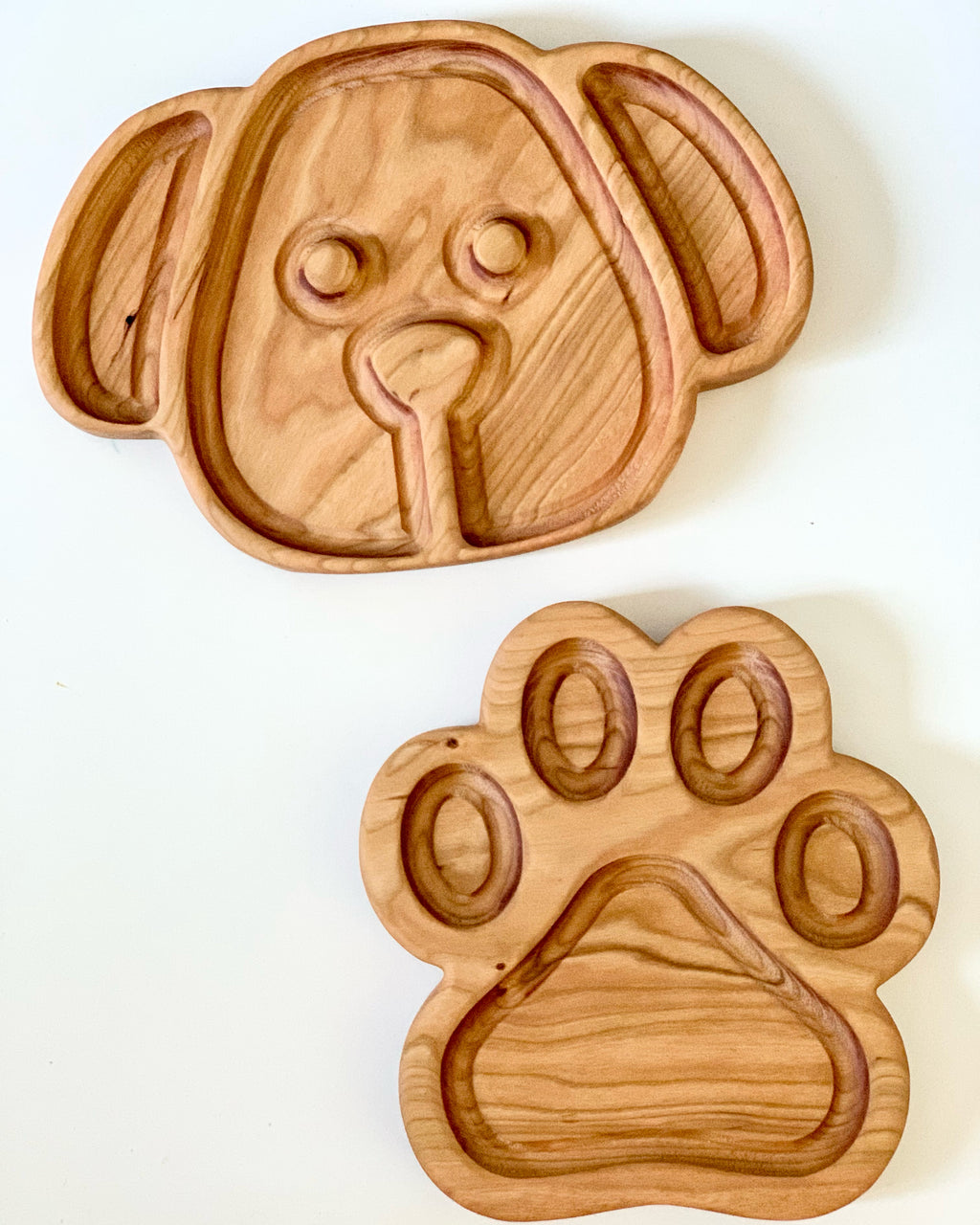 Wooden puppy dog face plate and paw-shaped sensory tray with carved compartments on white background
