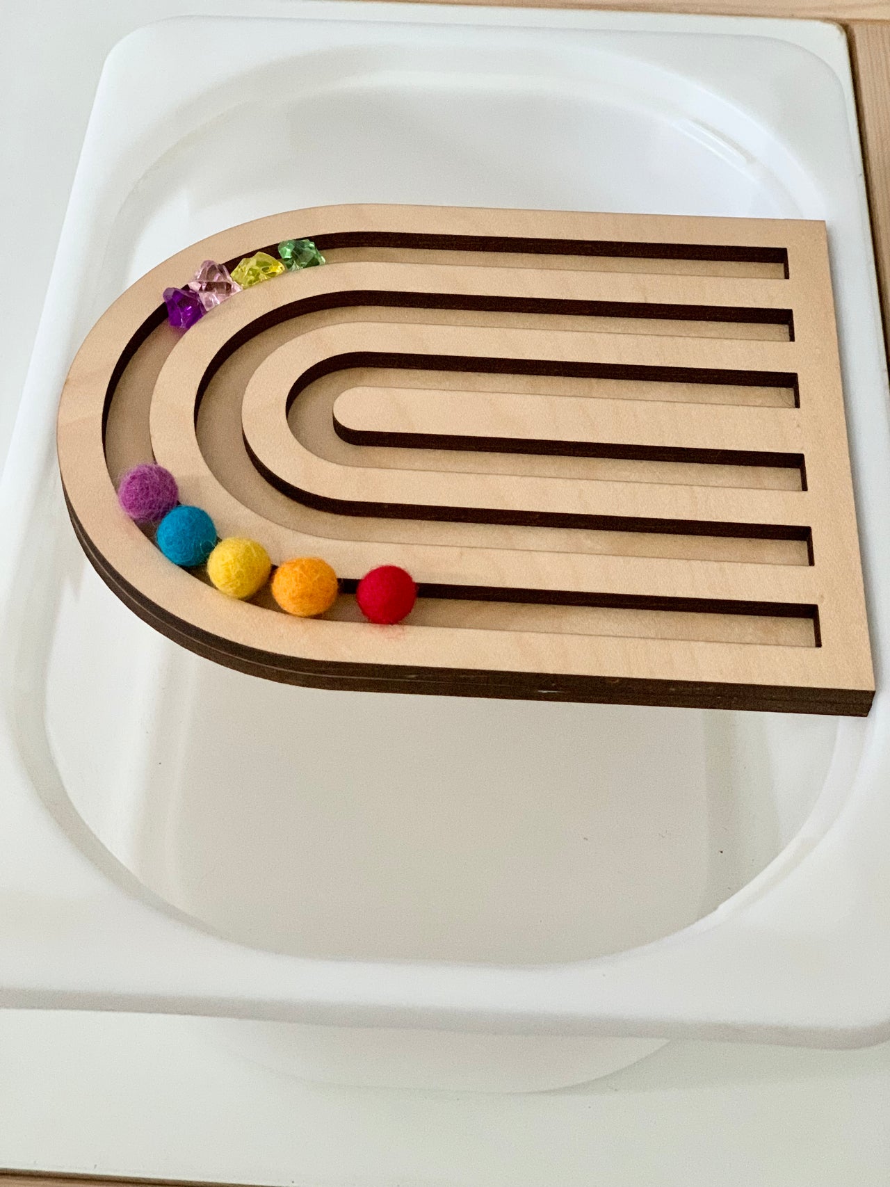 Laser cut wooden rainbow tray insert with felt balls and translucent beads on white small trofast bin tray