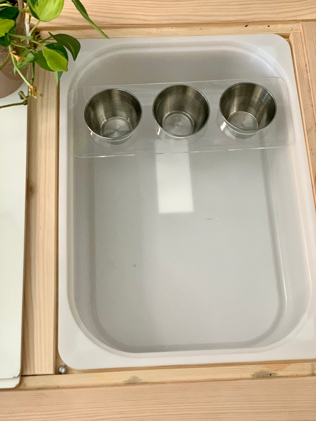 Clear acrylic Flisat table top insert with three removable metal cups fitted inside natural wood frame