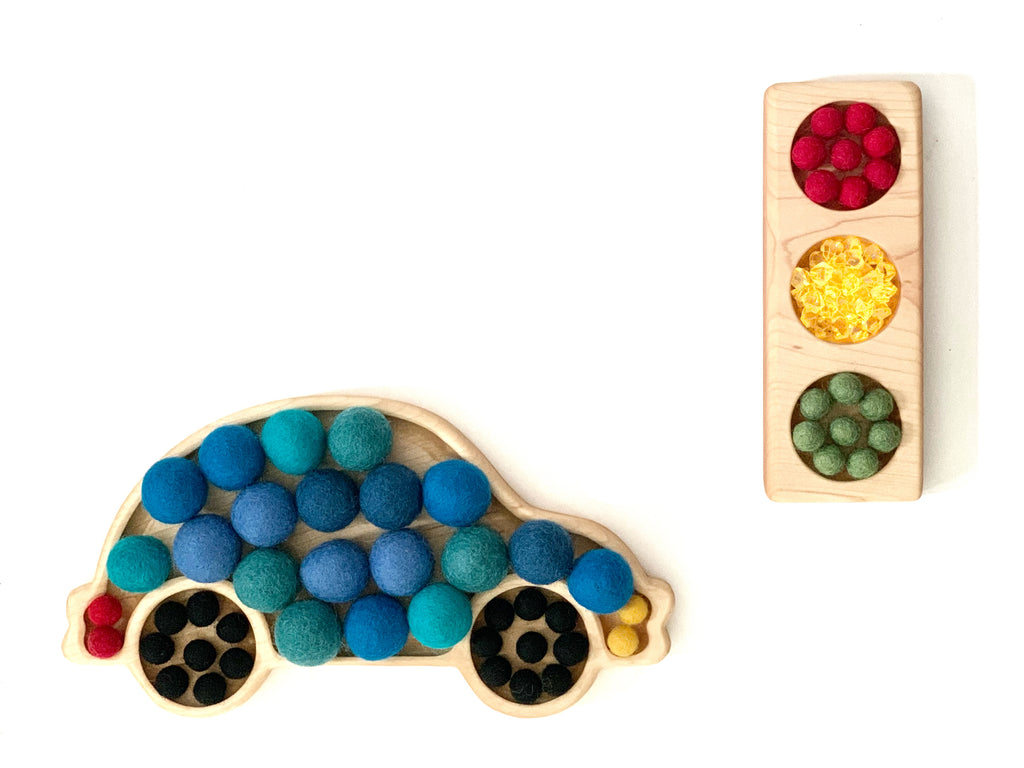 Wooden traffic light sensory tray with red, yellow, and green felt balls and car-shaped tray filled with blue felt balls