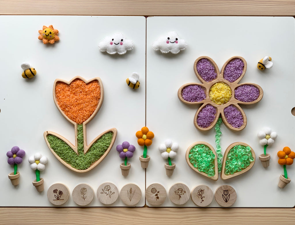Wooden flower trays filled with colorful textured materials surrounded by felt flower pots and smiling felt clouds with bees and sun