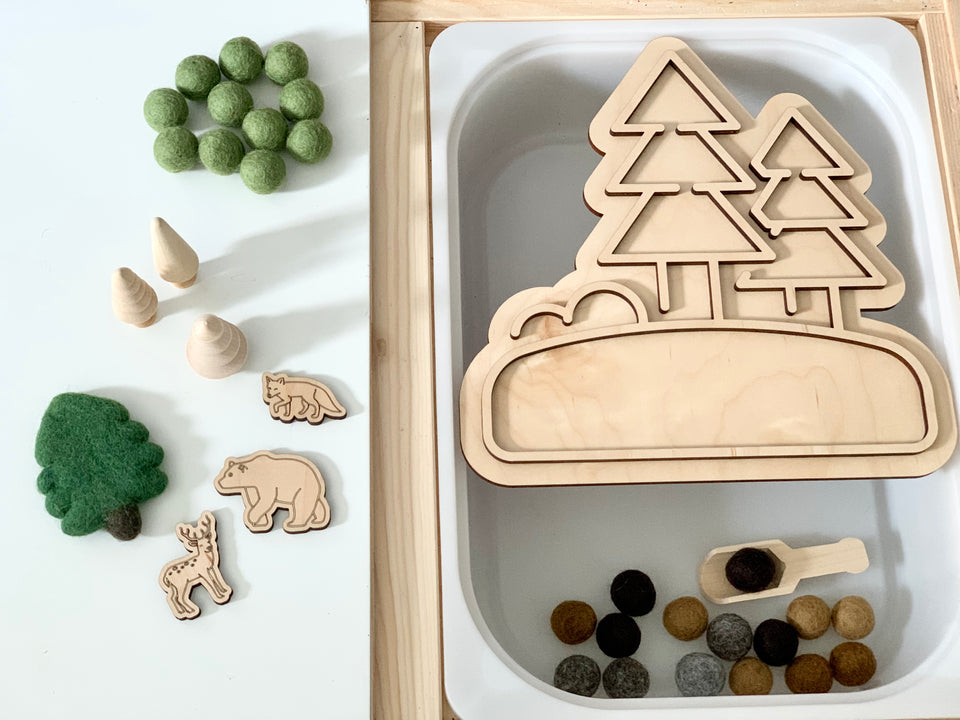 Maple plywood fillable woodland play tray insert with wooden tree shapes, felt balls, and small wooden animal figures on white surface